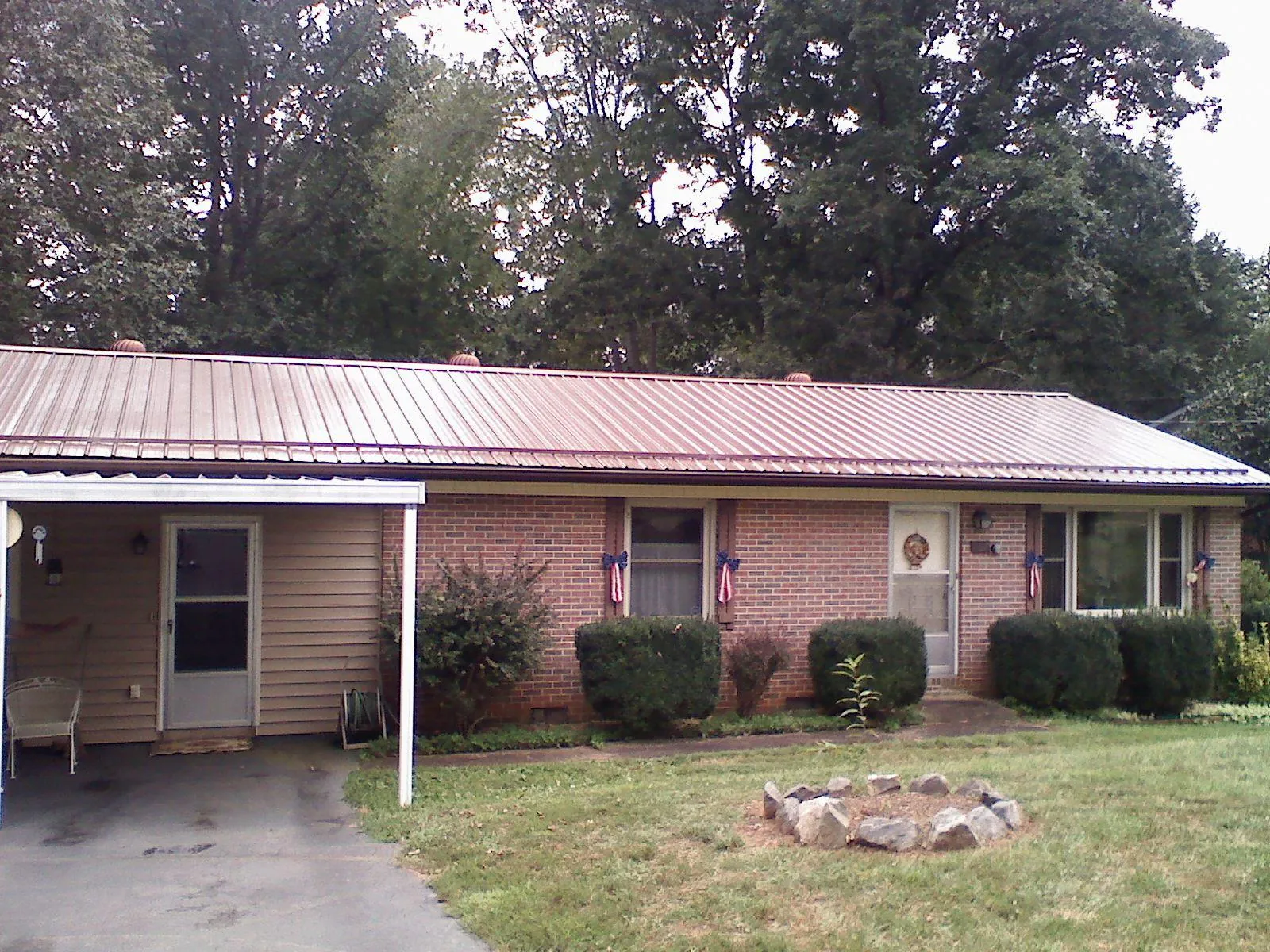 Bronze metal roof and carport on a brick ranch home — Roof Repair work by our crew in Thornton
